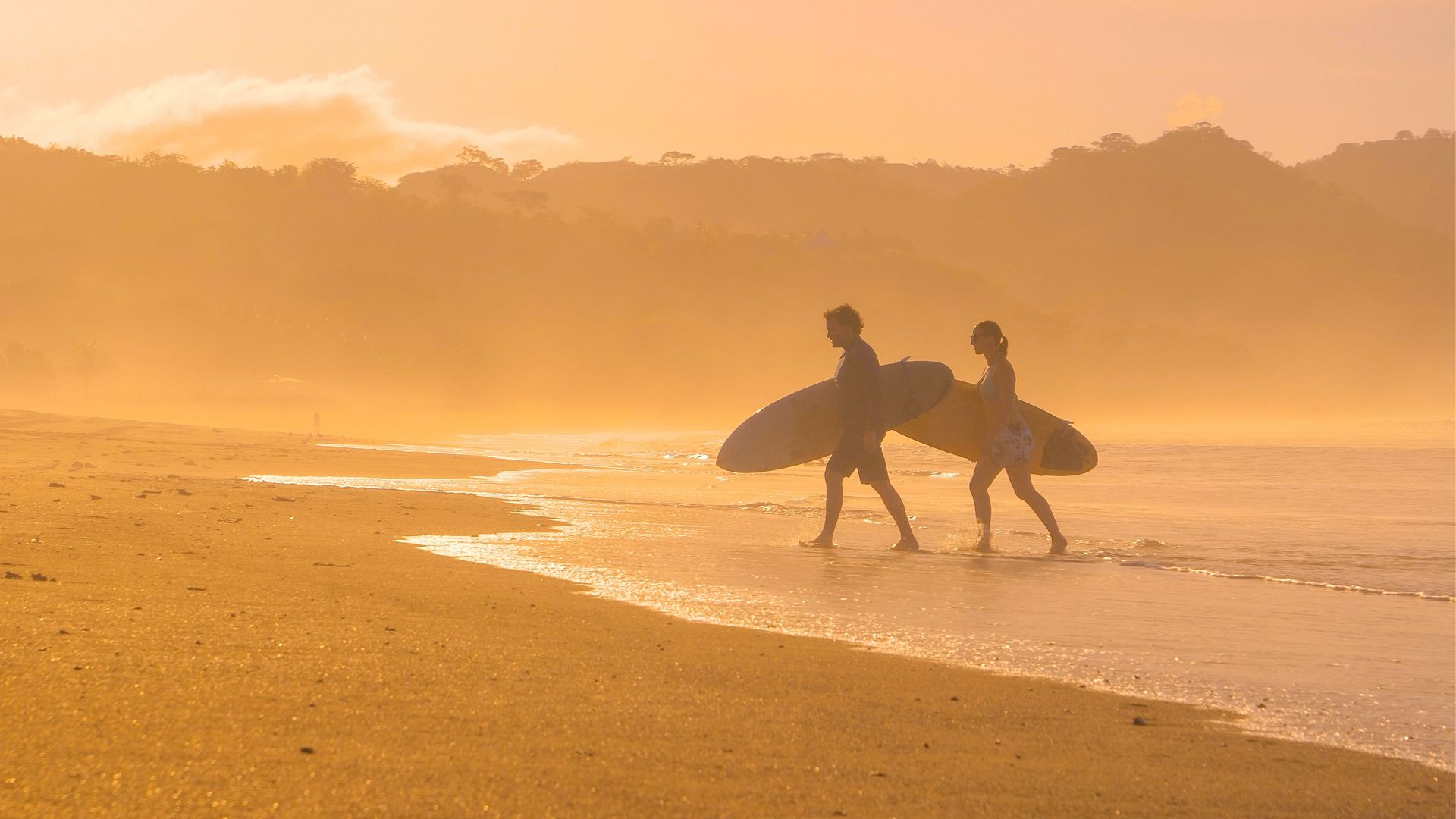 Deux surfeurs sur une plage du Panama au coucher du soleil