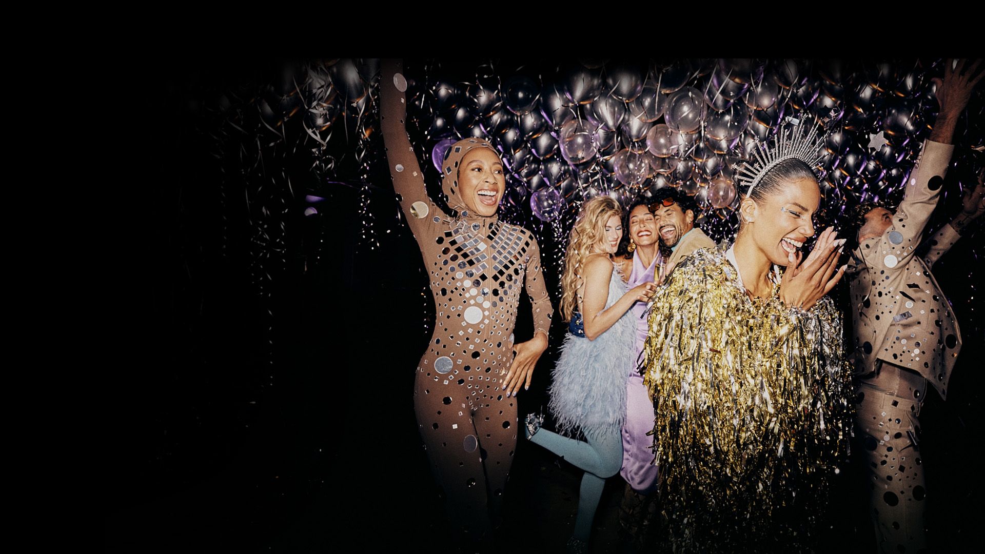 A group of people celebrating in a festive environment with balloons