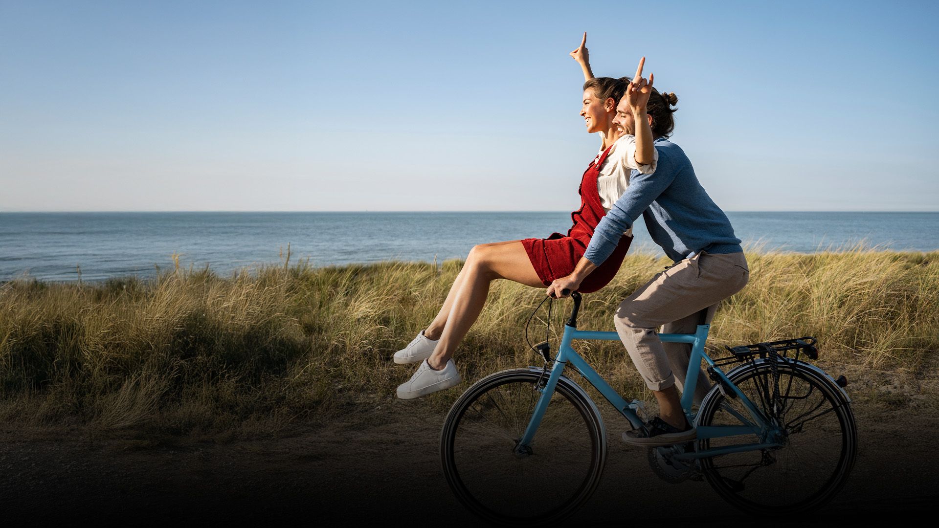 Un homme et une femme sur un vélo avec le logo de Gagnant à vie