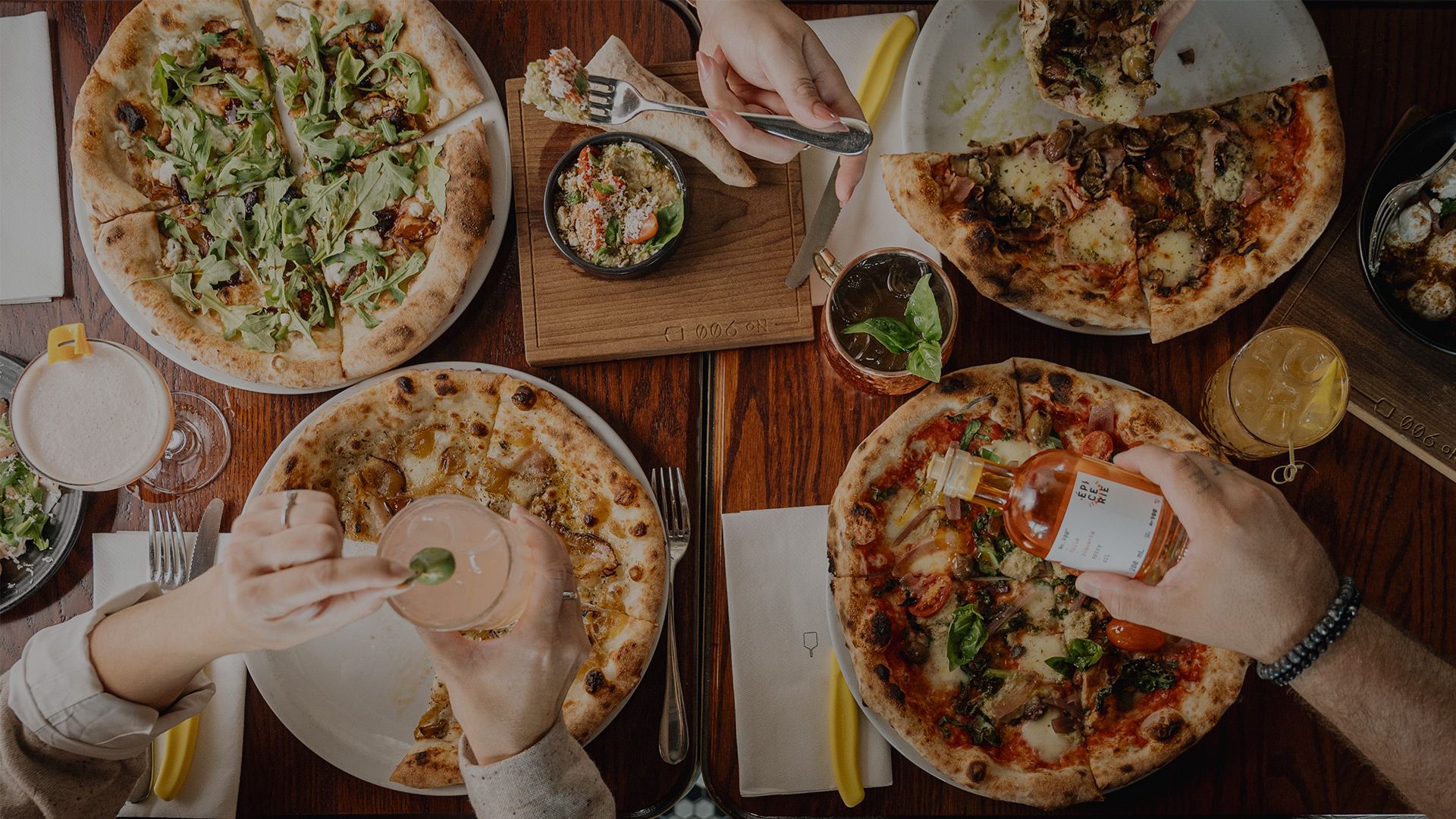 Assortment of Neapolitan pizzas and dishes served on a table viewed from above