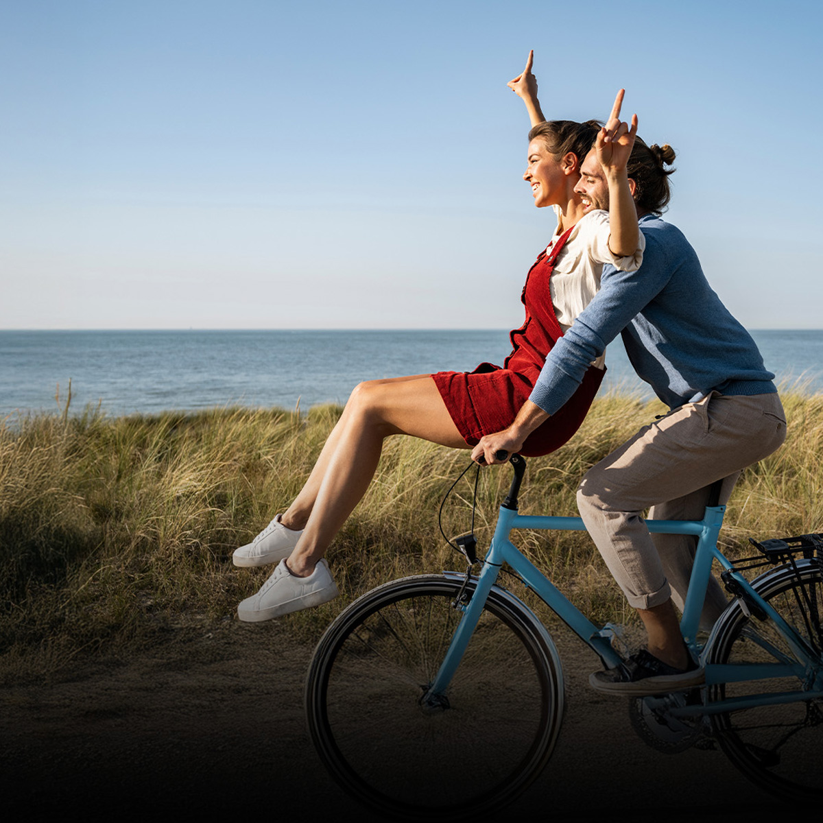 A man and a woman on a bike and the Gagnant à vie logo.